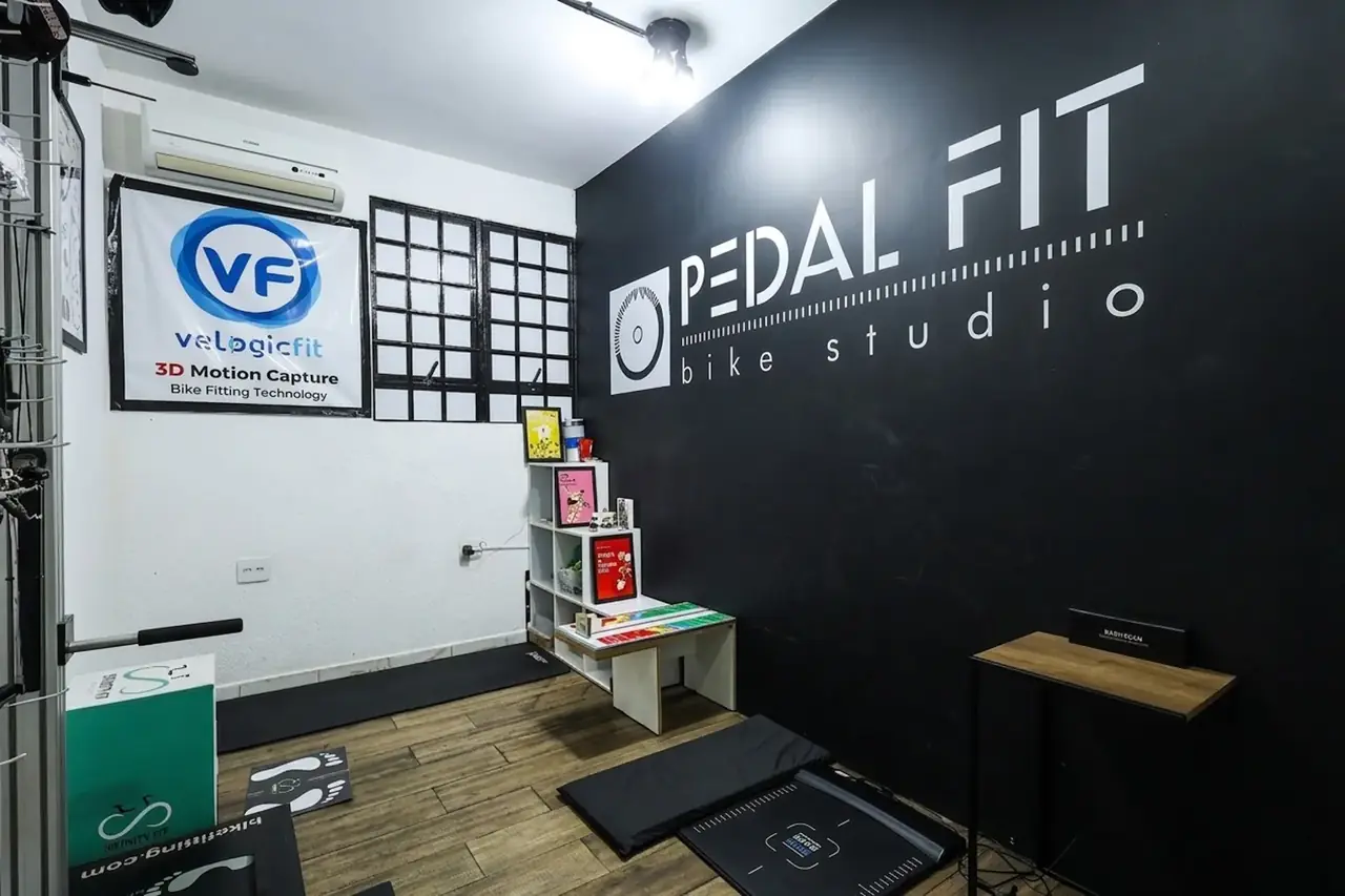 Sala de bike fit com a marca Pedal Fit na parede