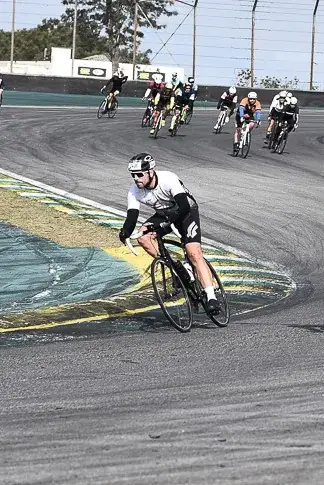 Ciclista pedalando em pista com outros ciclistas após sessão de bike fit